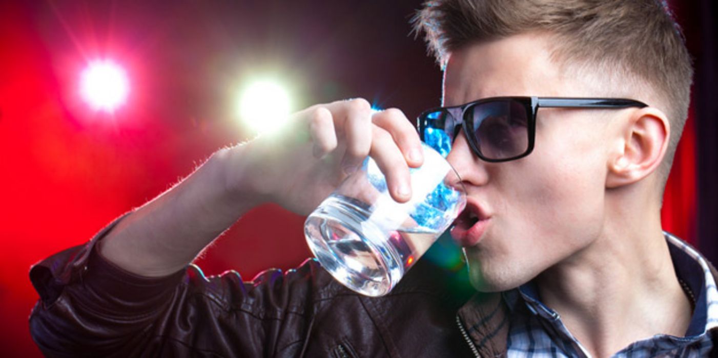 Jugendlicher mit Sonnenbrille trinkt Wodka.