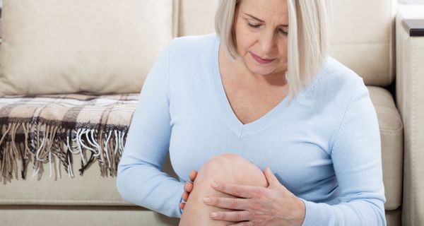 Frau über 50 Jahre hält sich das Knie