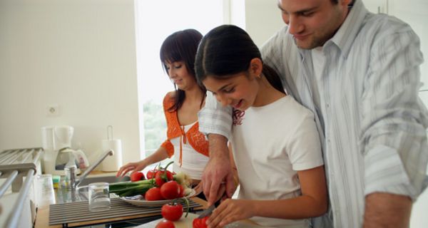 Junge Familie kocht mit Tomaten