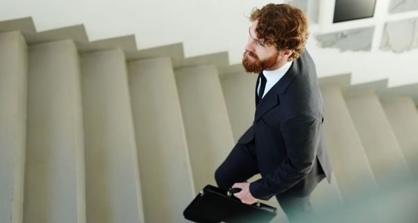 Mann im Anzug geht die Treppen hinauf.