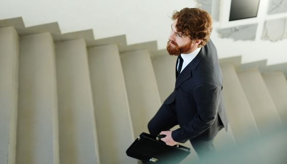 Mann im Anzug geht die Treppen hinauf.