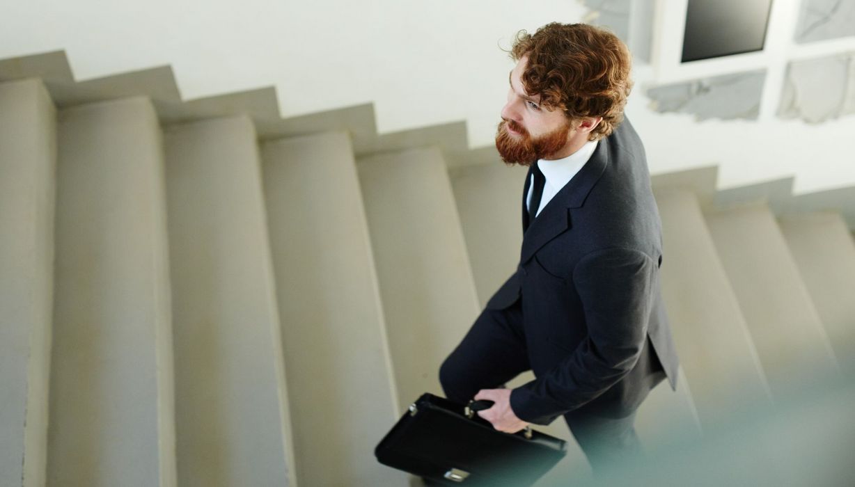 Mann im Anzug geht die Treppen hinauf.