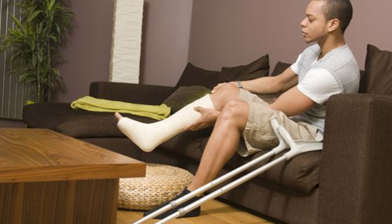 Mann mit Gipsbein auf dem Sofa