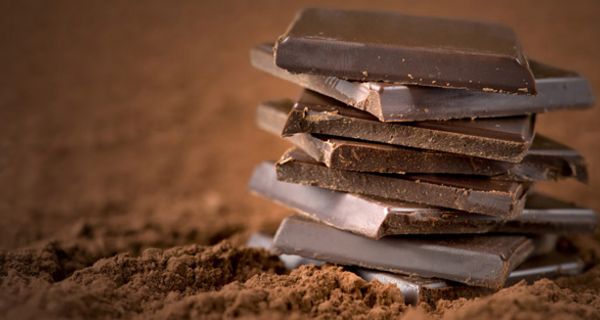 Gestapelte Schokoladenteile auf Kakao