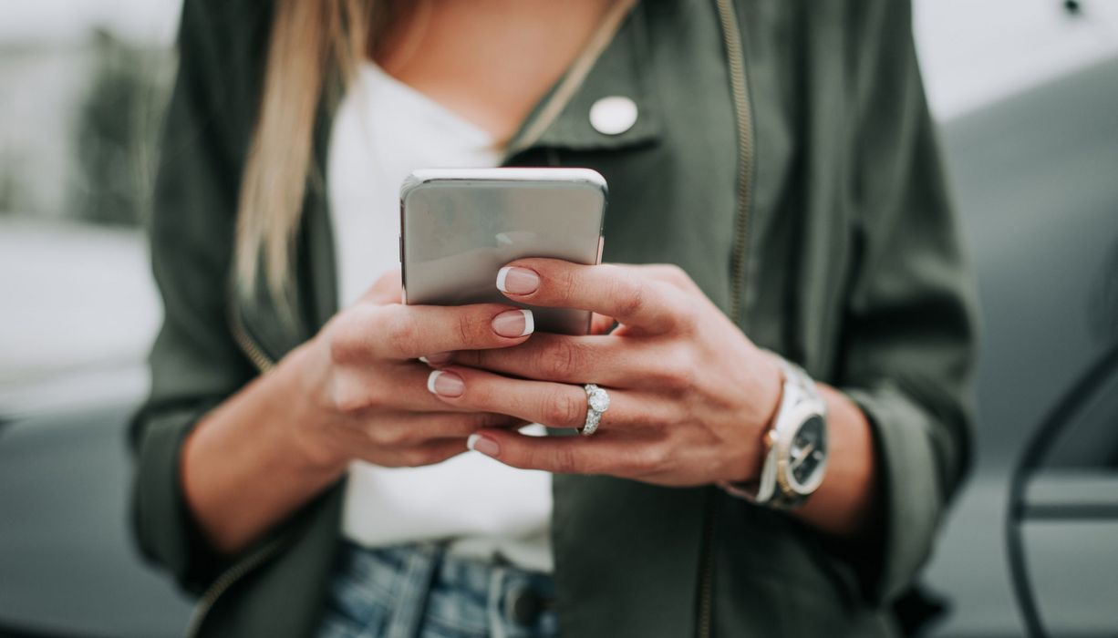 Frau mit Smartphone in der Hand.