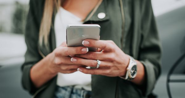 Frau mit Smartphone in der Hand.