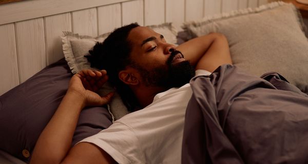 Ein Mann schläft in einem Bett.