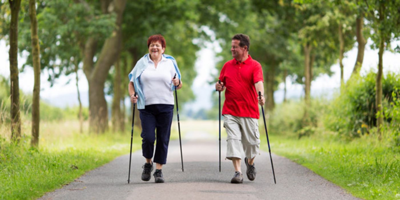 Paar macht Nordic Walking auf einer Allee