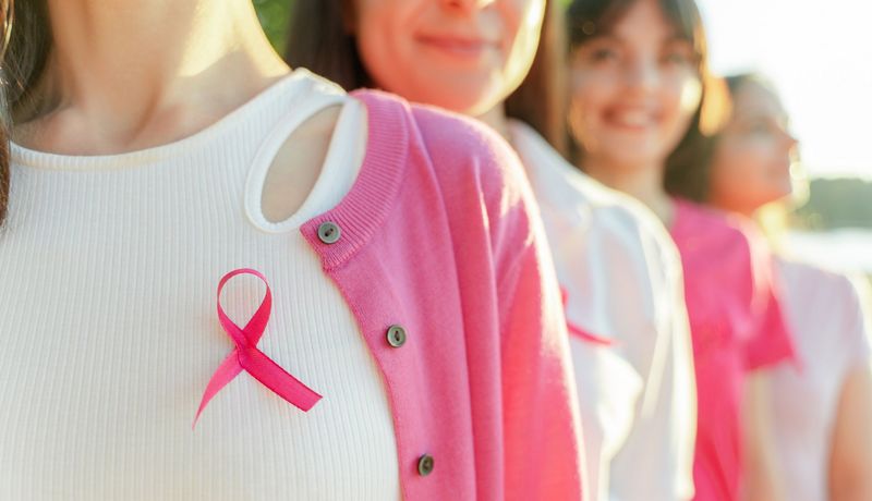 Junge Frauen mit rosa Brustkrebs-Schleife.