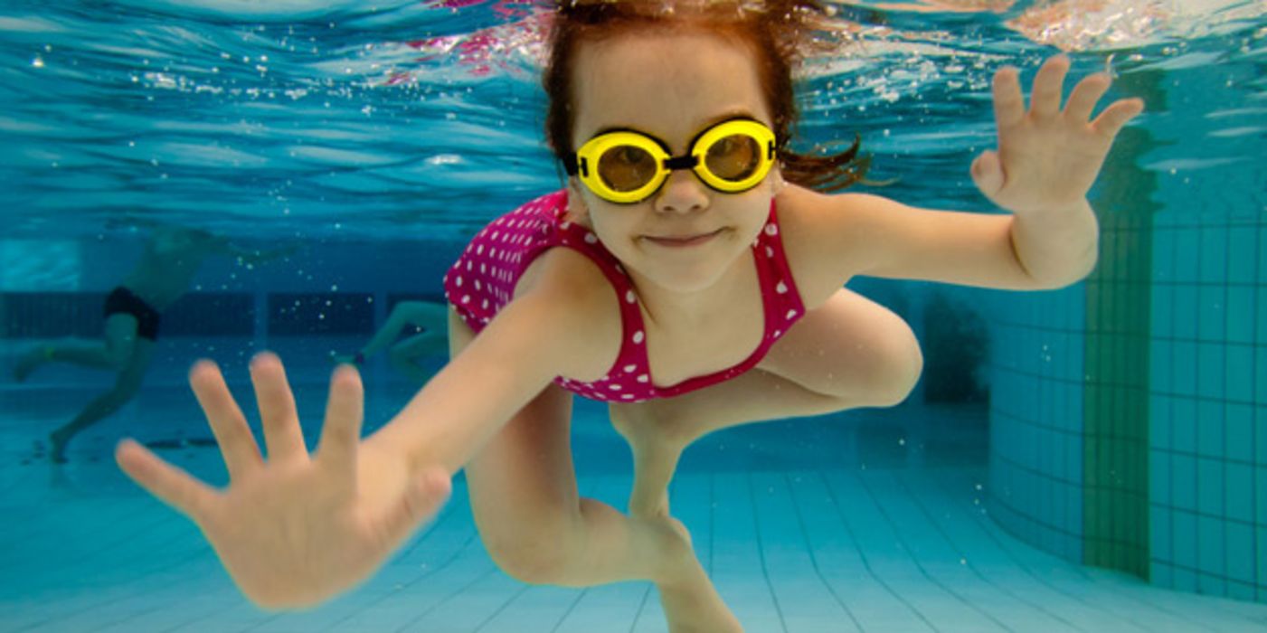 Mädchen mit Schwimmbrille unter Wasser