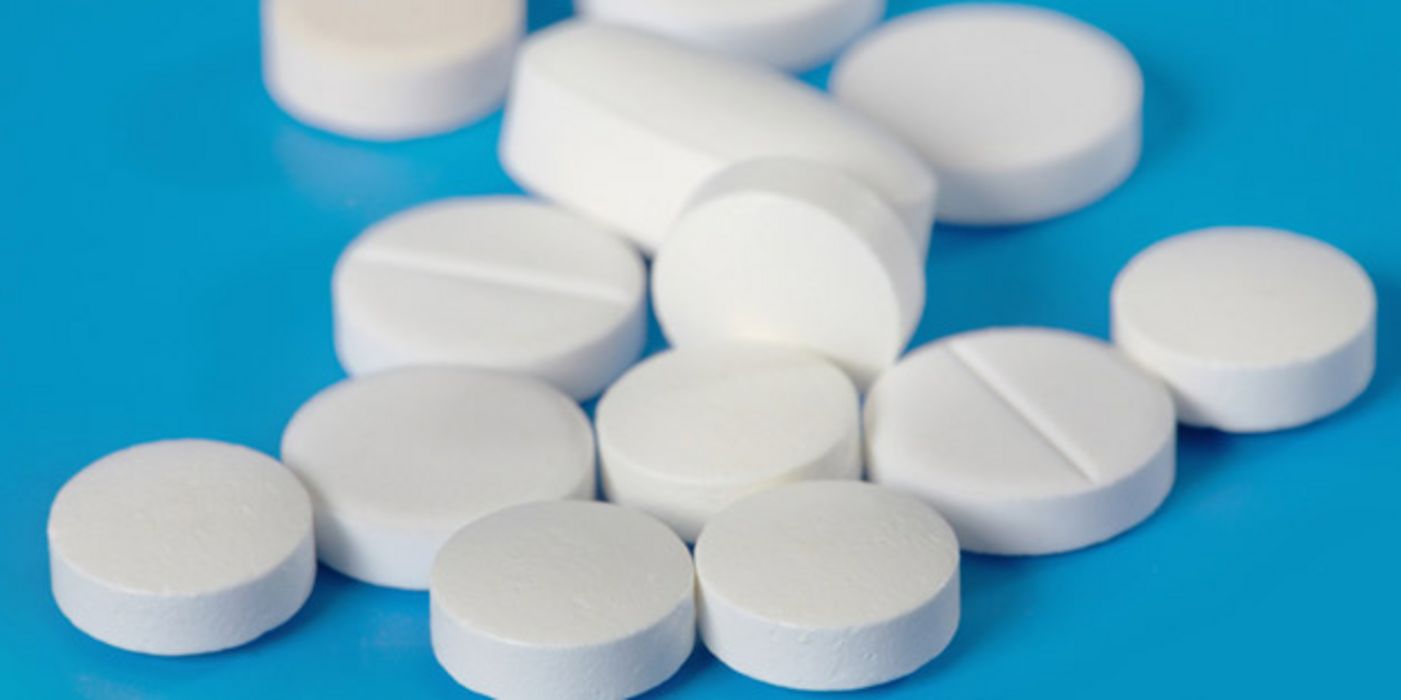 Weiße Tabletten auf einer blauen Fläche