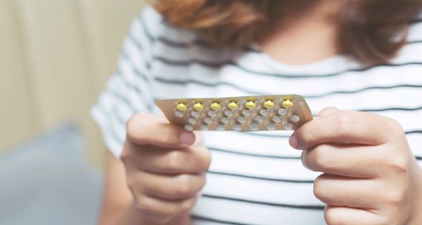 Frau, hält einen Blister der Antibabypille in der Hand.