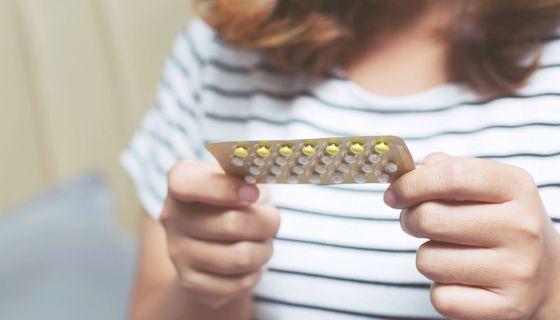 Frau, hält einen Blister der Antibabypille in der Hand.