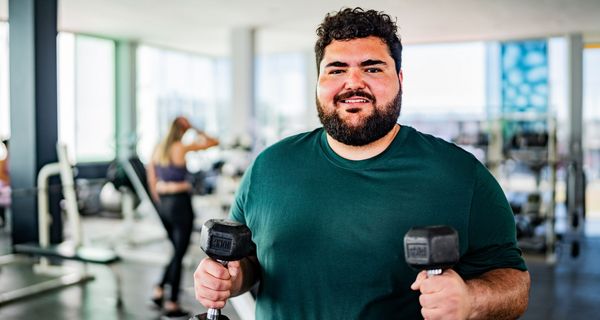 Übergewichtiger Mann im Fitnessstudio.