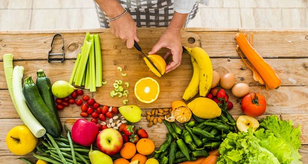 Buntes Obst und Gemüse auf einem Holztisch.