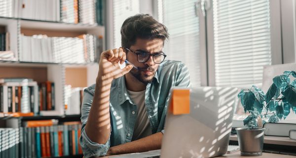 Mann sitzt vor Laptop 