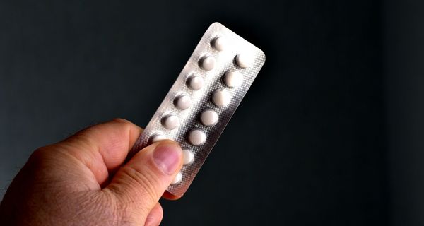 Mann, hält ein Blister Tabletten in der Hand.