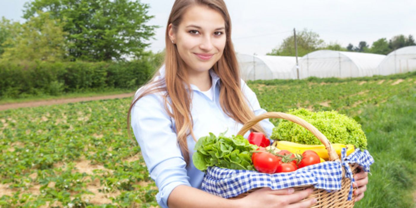 Junge Frau mit Obst- und Gemüsekorb
