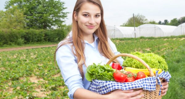 Junge Frau mit Obst- und Gemüsekorb