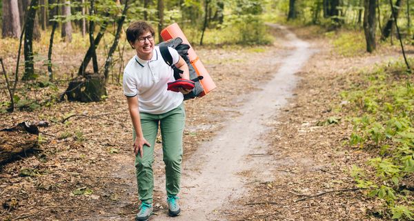 Frau, die im Wald wandert, hält sich das Knie.