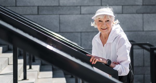 Ältere Frau, läuft eine Treppe hoch.