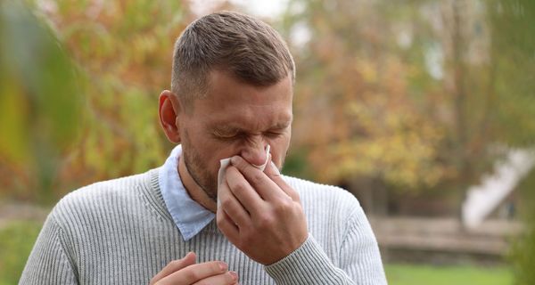 Mann niest im Stadtpark.