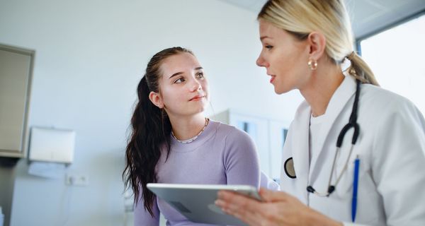 Ärztin spricht mit junger Patientin.