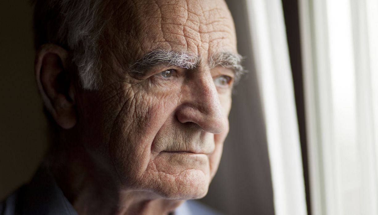 Senior, schaut traurig in die Ferne.