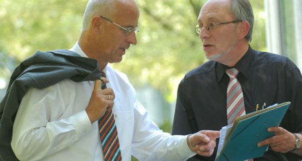 Zwei Männer in Anzügen besprechen sich.