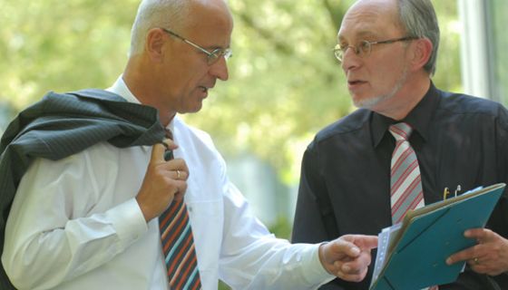 Zwei Männer in Anzügen besprechen sich.