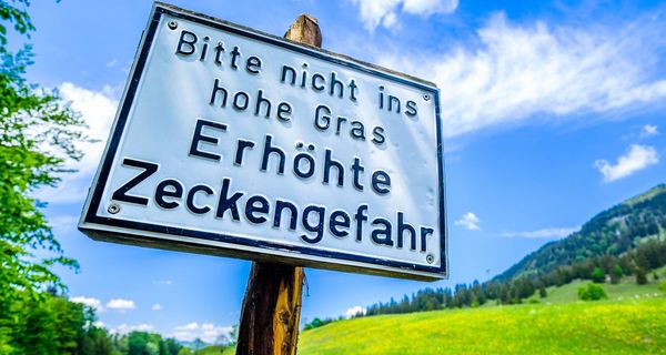 Schild mit Warnung vor Zecken.