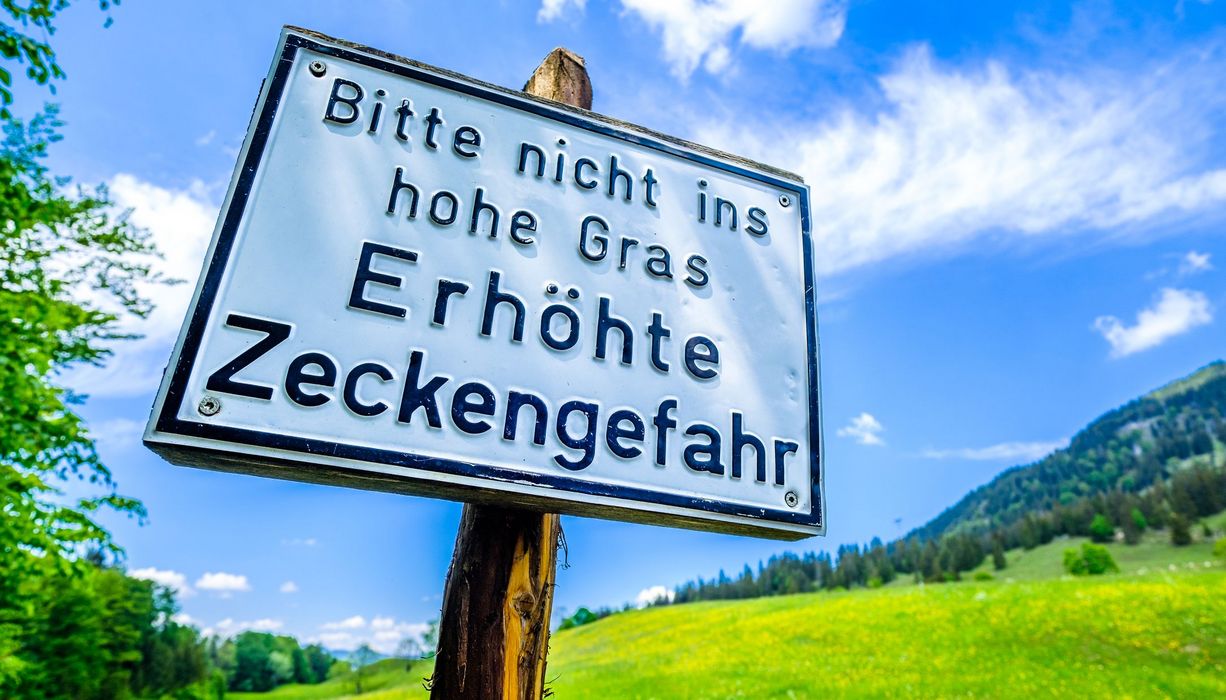 Schild mit Warnung vor Zecken.