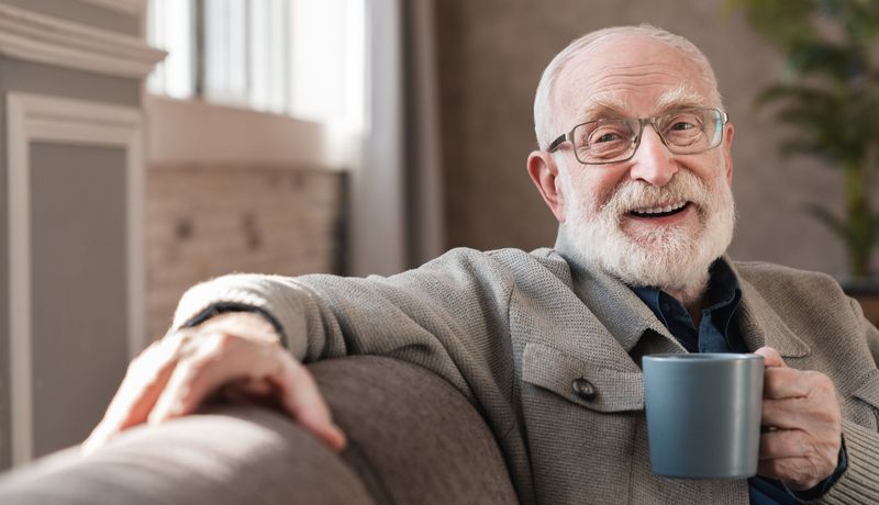 Älterer Mann trinkt eine Tasse Kaffee.