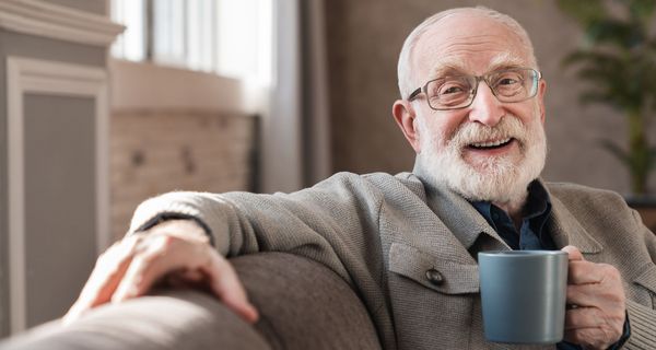Älterer Mann trinkt eine Tasse Kaffee.