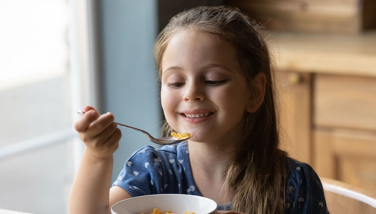Kind, etwa fünf Jahre alt, isst Cornflakes.