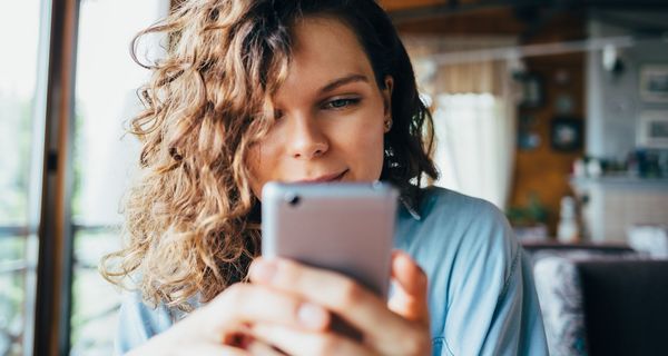 Junge Frau, tippt auf ihrem Smartphone.