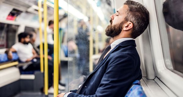 Mann, erschöpft in der Bahn.