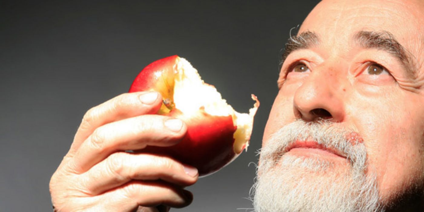 Senior isst Apfel.