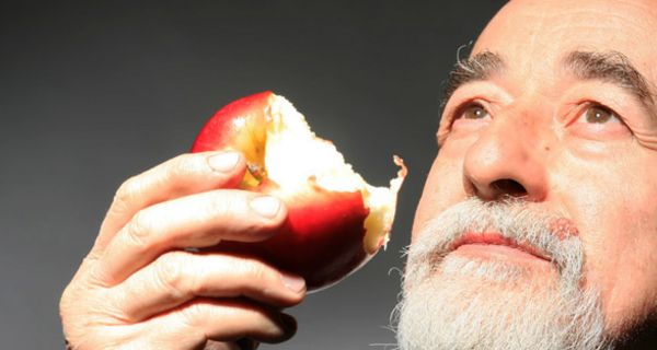 Senior, der in Apfel beißt