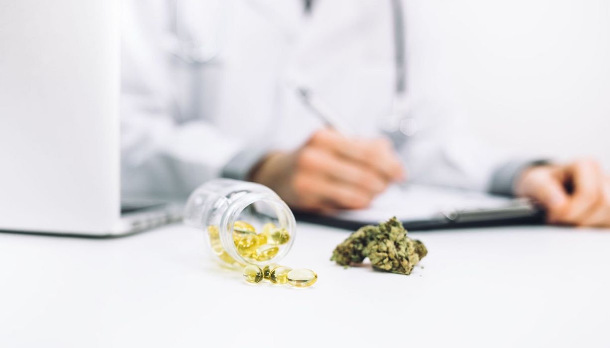 Arzt mit medizinischem Cannabis vor sich auf dem Tisch.