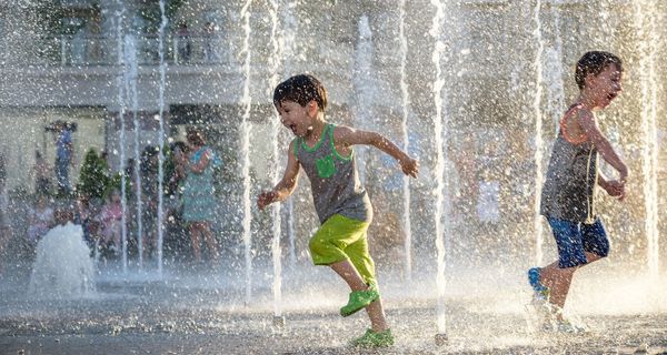 Zwei Jungs, spielen draußen in einem Brunnen.