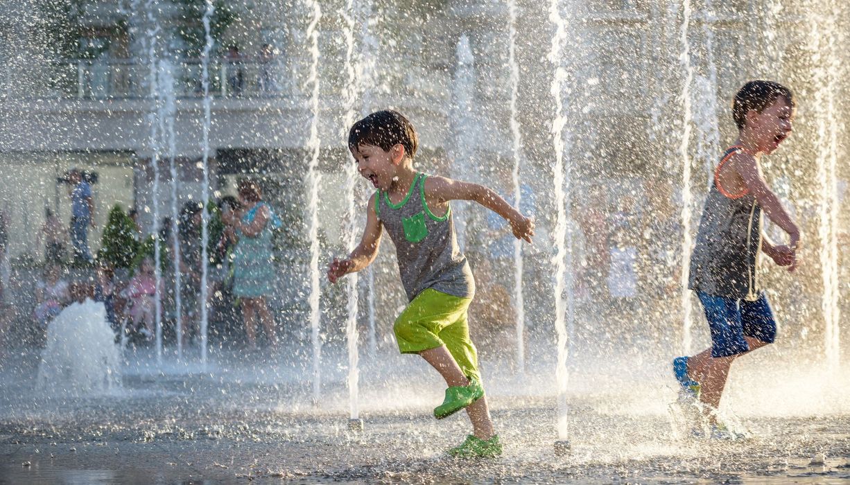 Zwei Jungs, spielen draußen in einem Brunnen.