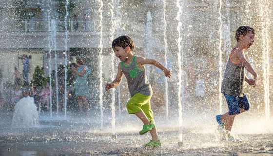 Zwei Jungs, spielen draußen in einem Brunnen.