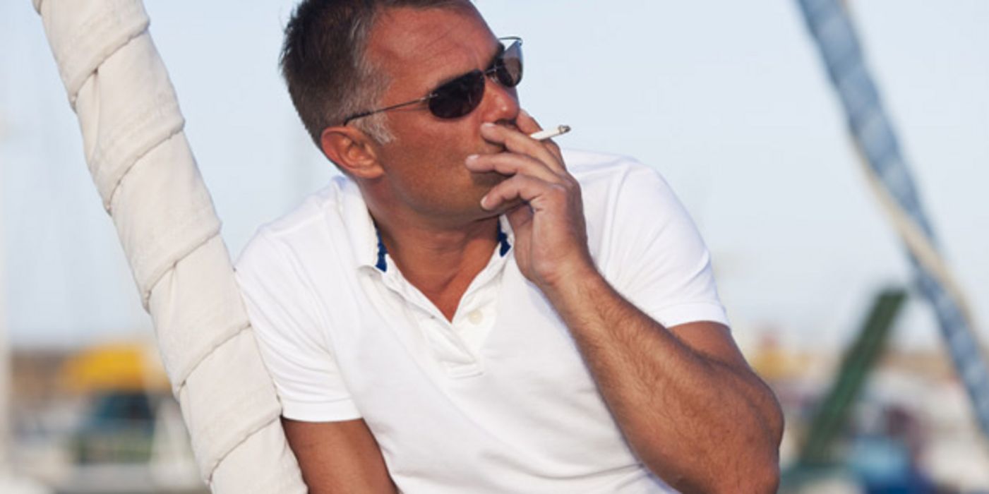 Mann mit Sonnenbrille raucht.