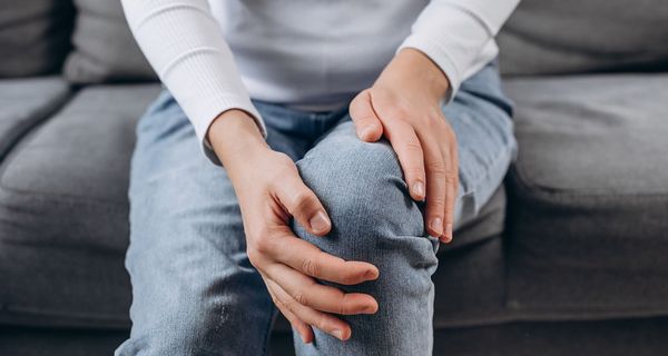 Frau, hält ihre Hände an ihre Knie.