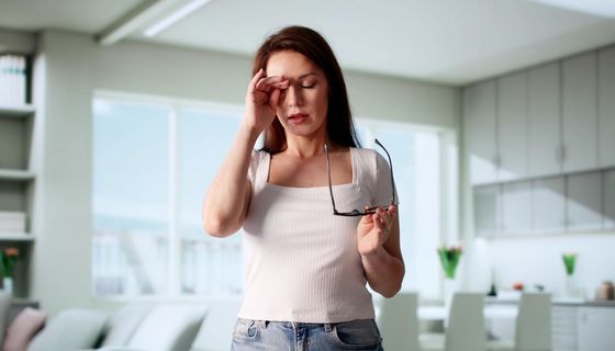 Frau reibt sich das Auge.