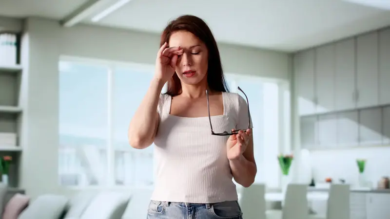 Frau reibt sich das Auge.