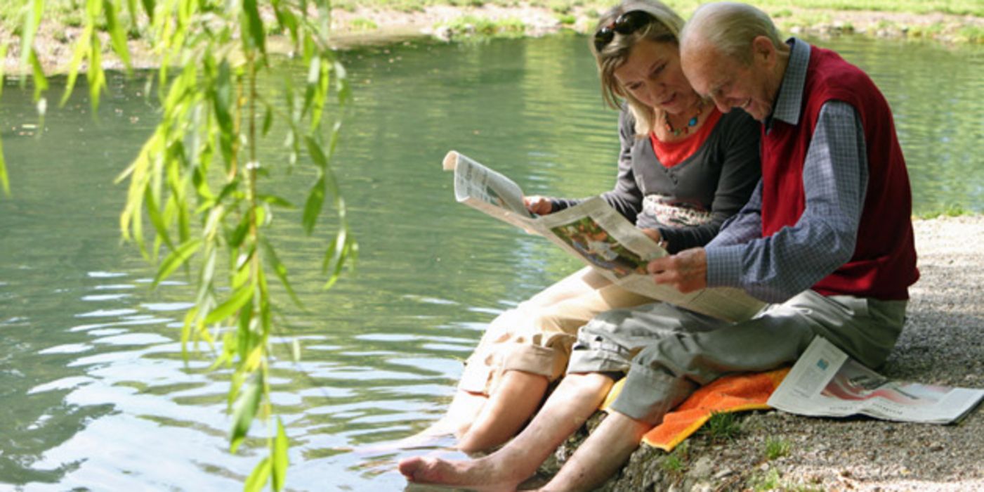 Älteres Paar sitzt am Kanalufer