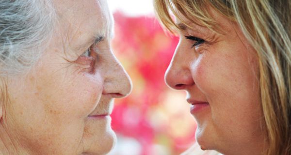 Zwei Frauen, die sich ansehen. Eine ist Mitte 40, die andere um die 80 Jahre alt.