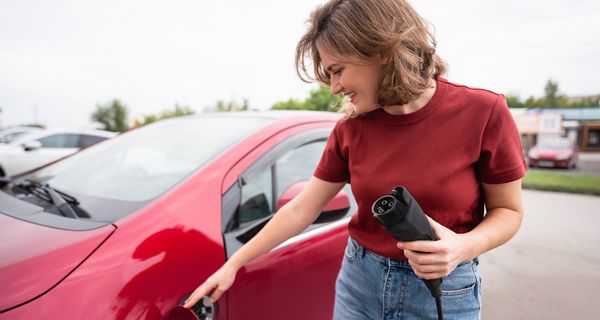 Eine Frau lädt ihr Elektro-Fahrzeug.